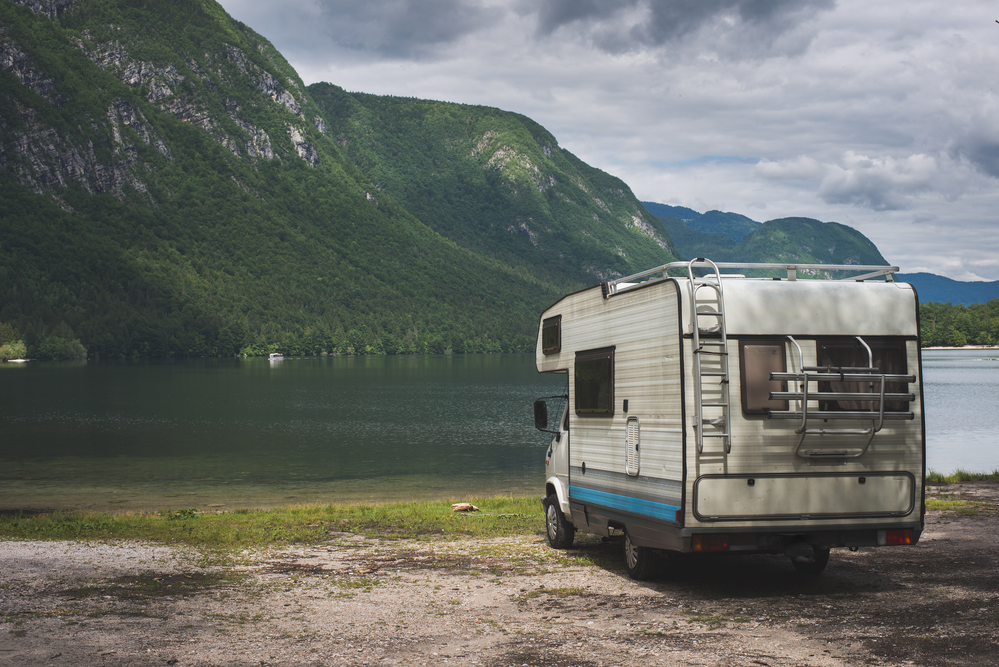 Wohnmobil steht in der Natur an einem See
