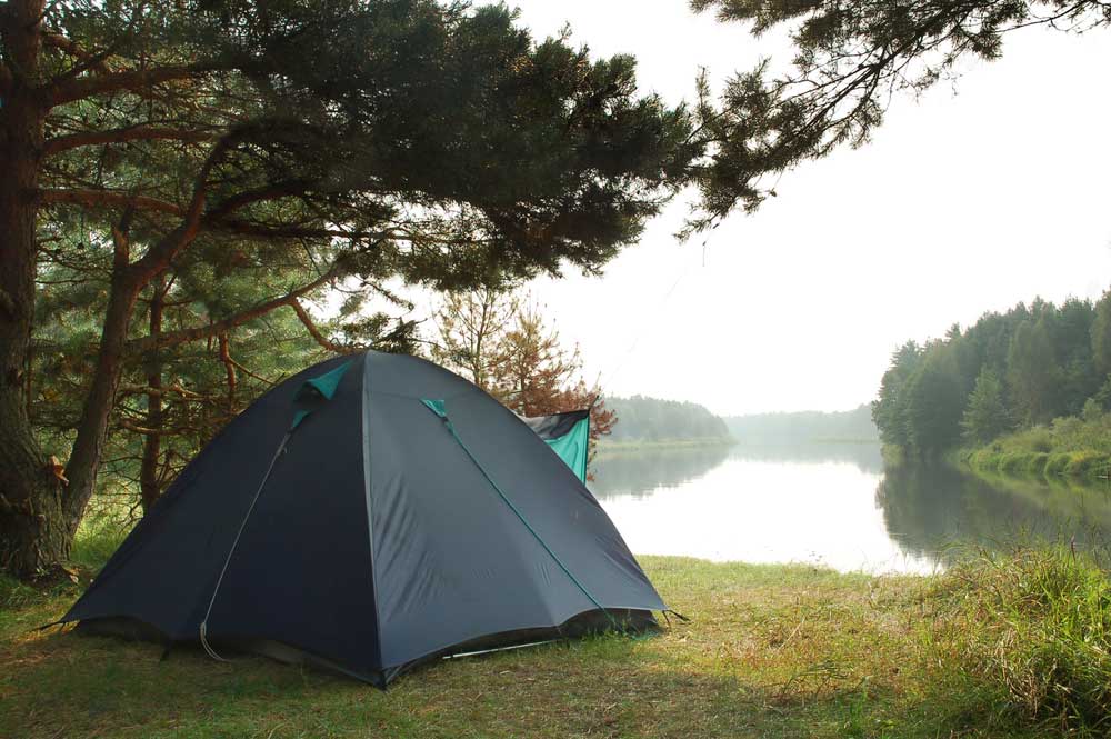 Schwarzes Zelt direkt an einem See aufgebaut