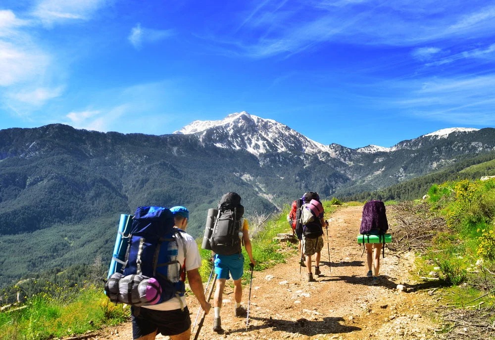 Gruppe beim Wandern mit Rucksack auf Berg.
