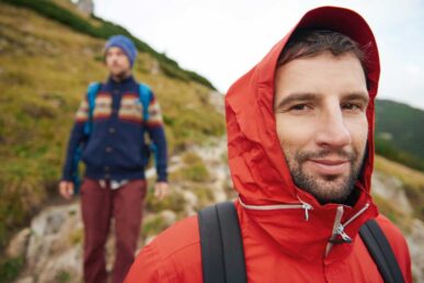 Mann mit roter Softshelljacke beim Wandern
