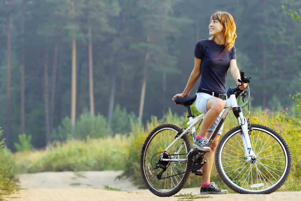 Frau fährt Fahrrad in der Natur mit gutem Sattel ohne Schmerzen