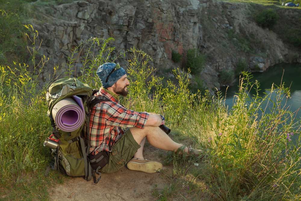 Mann mit Isomatte beim Wandern